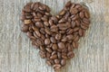 Coffe beans heart on wood background Royalty Free Stock Photo