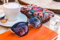 Coffe cappuccino, orange notebook, glass of water and colorful accessories