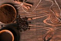 Coffe cup, coffee beans, ground coffee on wooden table background with cinnamon. Top view Royalty Free Stock Photo