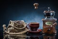 Coffe mill cup and sack with beans on mirror table Royalty Free Stock Photo