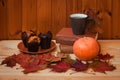 Coffee, autumn maple leaves, pumpkin, books and vanilla muffins on wooden table