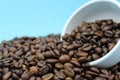 Roasted coffee beans tipped over on white glass Royalty Free Stock Photo