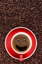 Coffee background of a cup of black coffee with smiling face coffee bubble on background of roasted arabica coffee beans