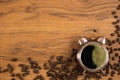 Coffee background of hot black coffee with foam in alarm clock cup wooden table with roasted coffee beans scattered around in Royalty Free Stock Photo
