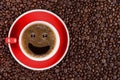 Coffee background of hot black coffee with smile bubble in red cup on roasted arabica coffee beans background Royalty Free Stock Photo