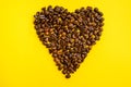 Coffee bean heart isolated on yellow background Royalty Free Stock Photo