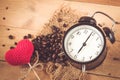 Coffee bean with love heart morning clock on wood Royalty Free Stock Photo