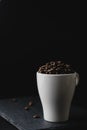 Coffee bean on a white cup over a rock stone slate Royalty Free Stock Photo