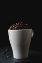 Coffee bean on a white cup over a rock stone slate. Royalty Free Stock Photo