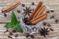 Coffee beans and aromatic spices on a wooden background in a glass vase