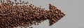 Coffee Beans Arranged in an Arrow Shape Pointing to the Right on a Grey Background for Creative Presentation and Design Royalty Free Stock Photo