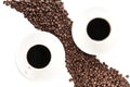 Coffee beans arranged diagonally with coffee cups on white Royalty Free Stock Photo