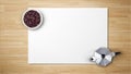 Coffee beans in bowl with coffee maker on white paper