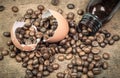 Coffee beans and broken egg peel on wooden table. Royalty Free Stock Photo