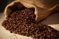 Coffee beans in burlap sack against dark wood Royalty Free Stock Photo