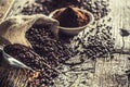 Coffee beans in burlap sack on old wooden table Royalty Free Stock Photo