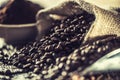 Coffee beans in burlap sack on old wooden table Royalty Free Stock Photo