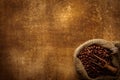 Coffee beans in burlap sack over grunge background