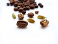 Coffee beans and cardamom grains are scattered on a white glossy surface