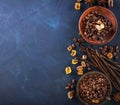 Coffee beans, chocolate drops, vanilla pods, cinnamon sticks, anise stars and brown sugar in a vintage silver cups on Royalty Free Stock Photo