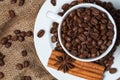 Coffee beans, cinnamon and aniseed in coffee cup.