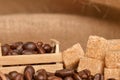 Coffee beans and cinnamon on a background of burlap. Roasted coffee beans background close up. Coffee beans pile from top with