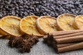 Coffee beans with citrus cinnamon sticks and star anise on the background of burlap Royalty Free Stock Photo