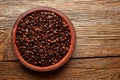 Coffee beans in a clay dish texture on wood Royalty Free Stock Photo