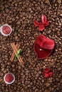 Coffee beans on a coffee beans background with red box with wedding ring, red flowers , red chocolate and cinnamon. Royalty Free Stock Photo