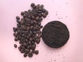 Coffee beans and coffee grounds on pink background