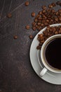 Coffee beans and coffee in a white cup on dark rusty background. Royalty Free Stock Photo