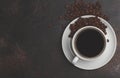 Coffee beans and coffee in a white cup on dark rusty background. Royalty Free Stock Photo