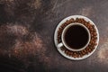 Coffee beans and coffee in a white cup on dark rusty background. Royalty Free Stock Photo