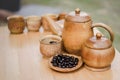 Coffee beans, cup of coffee and teapot on wooden desk. Royalty Free Stock Photo