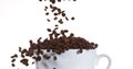 Coffee Beans Falling into a Cup against White Background Royalty Free Stock Photo