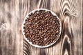 Coffee beans fresh roasted in round bowl on a wooden table