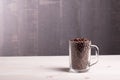 Coffee beans in a glass cup on a wooden table with Lightstone da Royalty Free Stock Photo