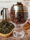 Coffee beans in a glass goblet and green tea on a plate Royalty Free Stock Photo