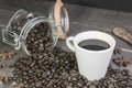 Coffee beans in glass jar with american black coffee cup on old wooden table.Concept of energy caffeine drink on rustic background Royalty Free Stock Photo