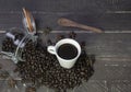 Coffee beans in glass jar with american black coffee cup on old wooden table.Top view of creative cafe concept on rustic Royalty Free Stock Photo