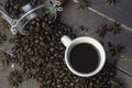 Coffee beans in glass jar with american black coffee in white cup on old wooden table.Top view of creative morning drink concept Royalty Free Stock Photo