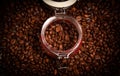 Coffee beans in glass jar standing on textured background of coffee beans. View from top Royalty Free Stock Photo
