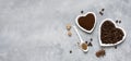 Coffee beans, ground coffee in white heart-shaped plates and instant coffee in a spoon on a gray background. Royalty Free Stock Photo