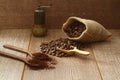 Coffee beans and ground coffee in wooden spoons on brown background. With old burlap bag and coffee grinder. Royalty Free Stock Photo