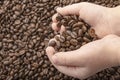 Coffee beans in hands with love heart on coffee background. Roasted coffee beans background Royalty Free Stock Photo