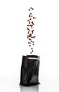 Coffee beans isolated on a white background are poured into a black packet