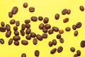 Coffee beans isolated on the yellow background. Joyful coffee-theme Royalty Free Stock Photo