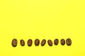 Coffee beans isolated on the yellow background. Joyful coffee-theme Royalty Free Stock Photo