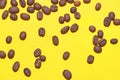 Coffee beans isolated on the yellow background. Joyful coffee-theme Royalty Free Stock Photo