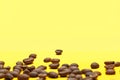 Coffee beans isolated on the yellow background. Joyful coffee-theme Royalty Free Stock Photo